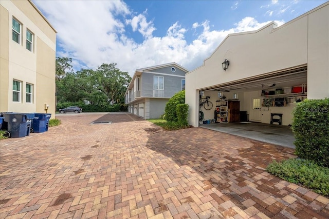view of property exterior featuring a garage, decorative driveway, and stucco siding
