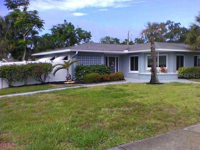 ranch-style home with a front yard and stucco siding