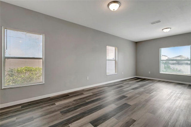 1107 Seminole Sky Dr, Ruskin, FL 33570 - spare room featuring dark wood-type flooring, healthy amount of natural light, and baseboards