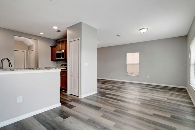 1107 Seminole Sky Dr, Ruskin, FL 33570 - kitchen with stainless steel microwave, wood finished floors, a sink, recessed lighting, and baseboards