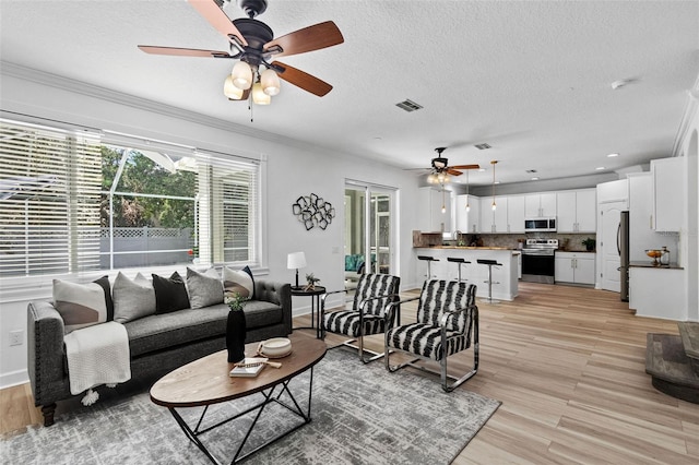 16206 Nottingham Park Way, Tampa, FL 33647 - living area featuring a ceiling fan, light wood-style floors, ornamental molding, a textured ceiling, and baseboards