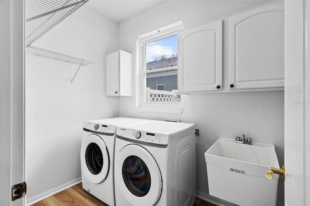 16206 Nottingham Park Way, Tampa, FL 33647 - laundry room with cabinet space, washer and clothes dryer, light wood finished floors, and baseboards