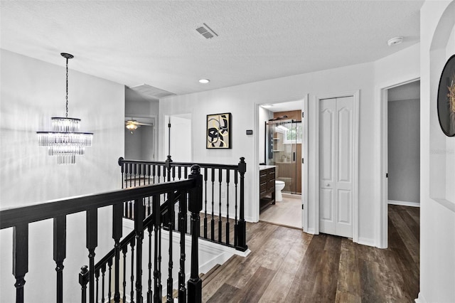 16206 Nottingham Park Way, Tampa, FL 33647 - hallway featuring an upstairs landing, dark wood-style floors, a chandelier, a textured ceiling, and baseboards
