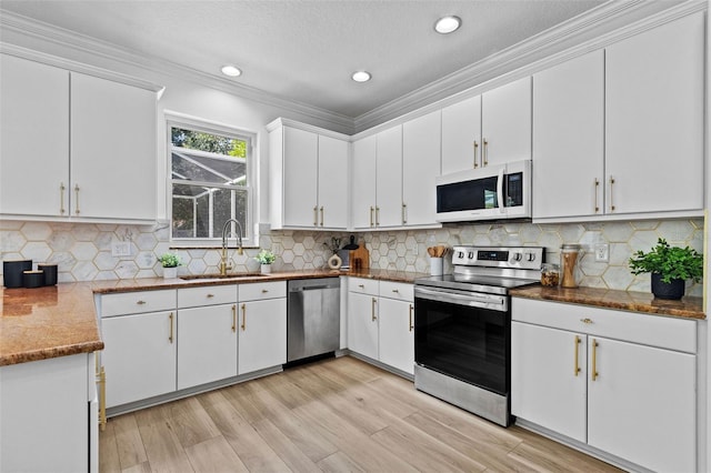 16206 Nottingham Park Way, Tampa, FL 33647 - kitchen with stainless steel appliances, ornamental molding, white cabinets, a sink, and light wood finished floors