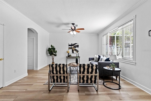 16206 Nottingham Park Way, Tampa, FL 33647 - living area featuring a ceiling fan, crown molding, arched walkways, light wood finished floors, and a textured ceiling