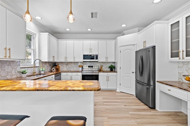 16206 Nottingham Park Way, Tampa, FL 33647 - kitchen featuring appliances with stainless steel finishes, a sink, a peninsula, white cabinets, and crown molding