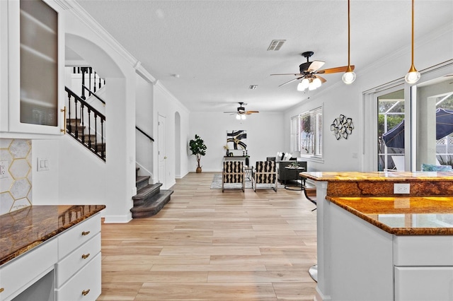 16206 Nottingham Park Way, Tampa, FL 33647 - kitchen with ceiling fan, light wood-style flooring, white cabinets, arched walkways, and ornamental molding