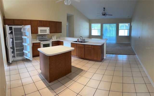 kitchen featuring white appliances, ceiling fan, a sink, a peninsula, and light countertops