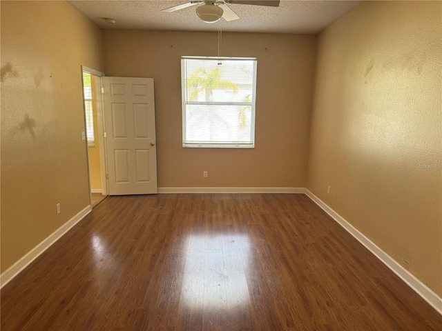 empty room with ceiling fan, dark wood-style floors, baseboards, and a smoke detector