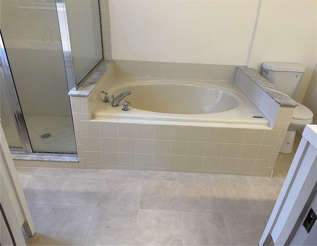 bathroom featuring a shower stall, toilet, a garden tub, and tile patterned flooring