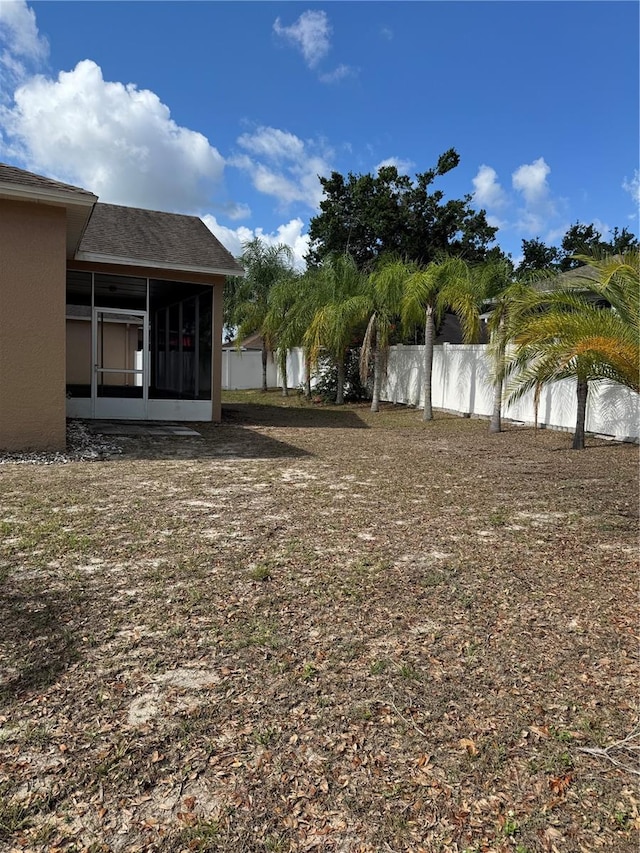 view of yard featuring a sunroom and fence