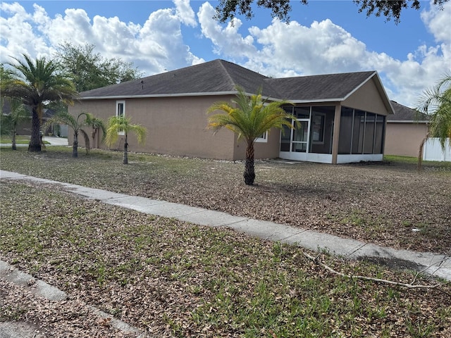 view of side of property with a sunroom and stucco siding