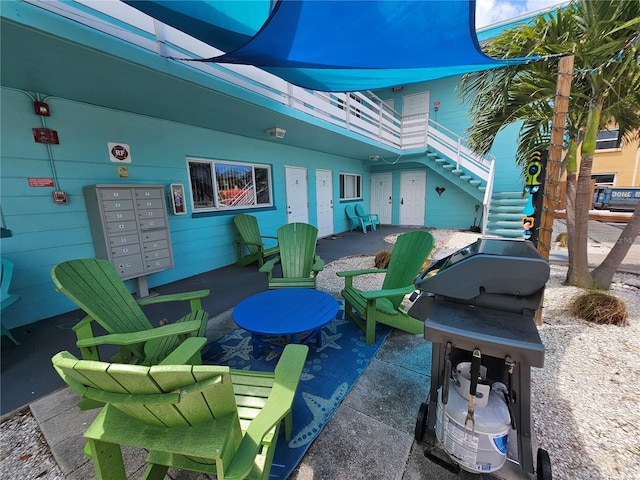 view of patio / terrace featuring mail area and stairway