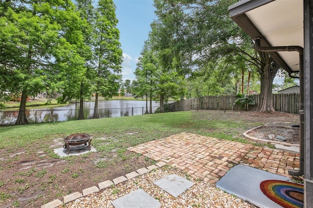 view of yard featuring an outdoor fire pit, a water view, and a patio area