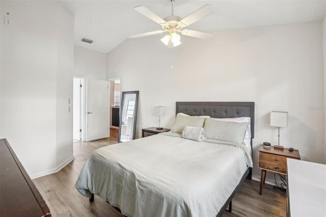 bedroom with wood finished floors, high vaulted ceiling, baseboards, and a ceiling fan