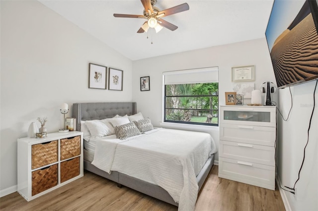 bedroom with vaulted ceiling, light wood finished floors, baseboards, and ceiling fan