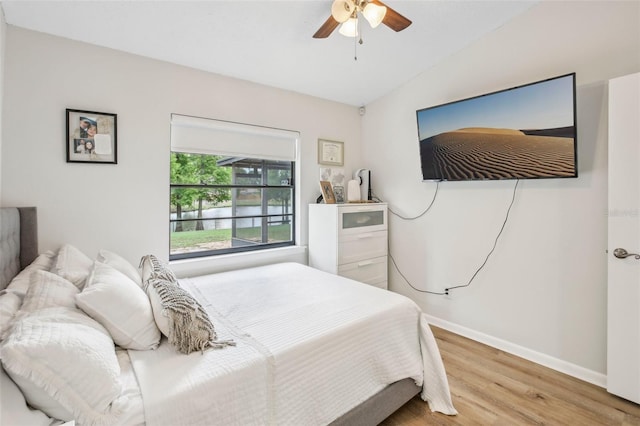 bedroom featuring wood finished floors, baseboards, and a ceiling fan