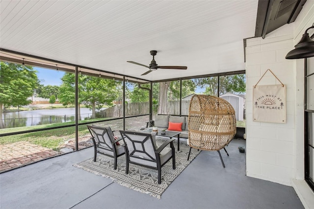 sunroom with a water view, an outdoor living space, and ceiling fan