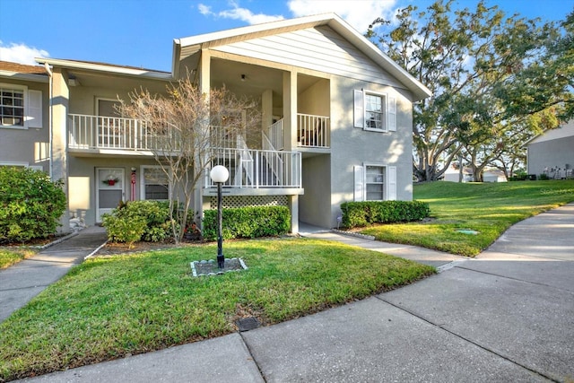 1390 Oak Hill Dr Unit 206, Dunedin, FL 34698 - townhome / multi-family property with stucco siding, a front lawn, and stairs