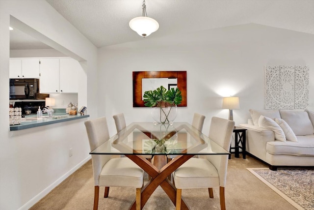 1390 Oak Hill Dr Unit 206, Dunedin, FL 34698 - dining room with lofted ceiling, light carpet, and baseboards