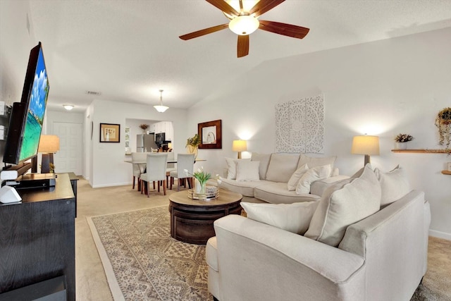 1390 Oak Hill Dr Unit 206, Dunedin, FL 34698 - living area with ceiling fan, light carpet, baseboards, and lofted ceiling