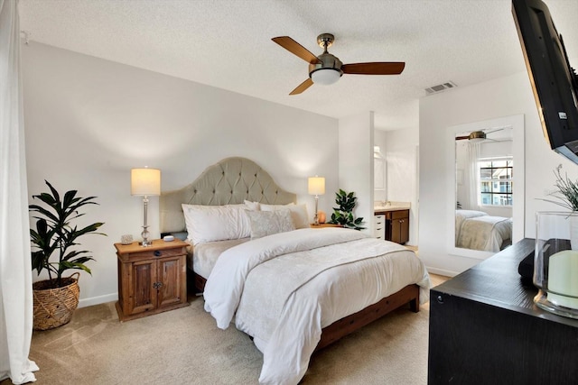 1390 Oak Hill Dr Unit 206, Dunedin, FL 34698 - bedroom featuring light colored carpet, baseboards, a textured ceiling, a ceiling fan, and ensuite bath