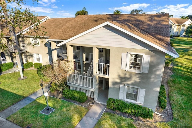 1390 Oak Hill Dr Unit 206, Dunedin, FL 34698 - townhome / multi-family property with stucco siding, a front yard, and a shingled roof