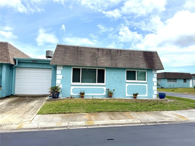 6880 Versailles N, Pinellas Park, FL 33781 - view of front of home featuring mansard roof, stucco siding, and roof with shingles