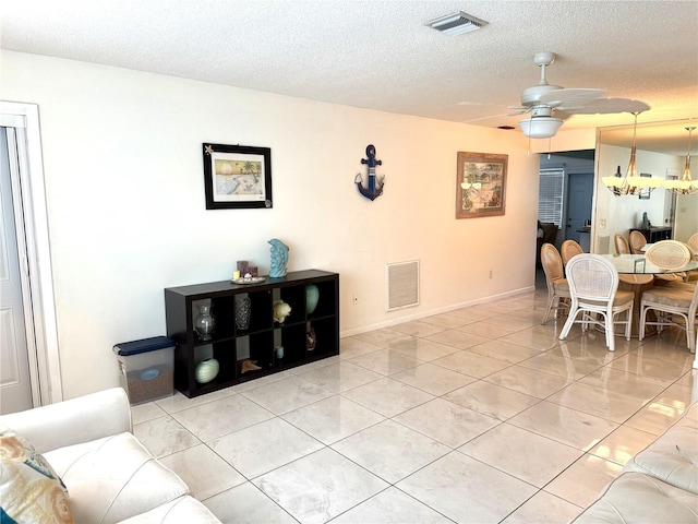 6880 Versailles N, Pinellas Park, FL 33781 - tiled living area with a textured ceiling, a ceiling fan, and baseboards