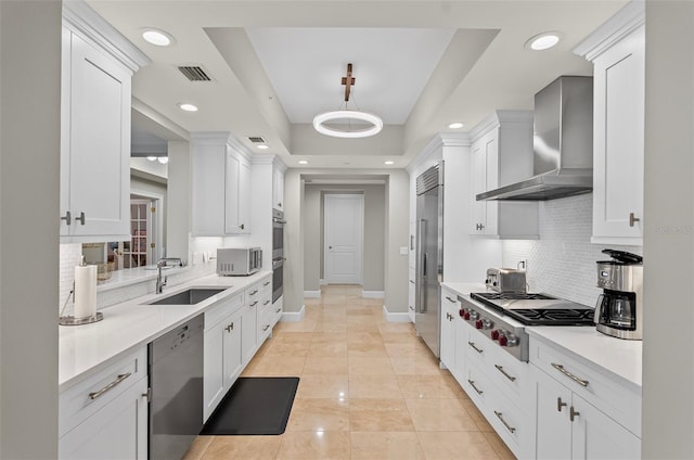 300 Beach Dr NE Unit 401, Saint Petersburg, FL 33701 - kitchen with wall chimney range hood, stainless steel appliances, a sink, tasteful backsplash, and light countertops
