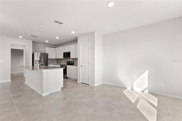9066 Rally Spring Loop, Wesley Chapel, FL 33545 - kitchen with appliances with stainless steel finishes, light tile patterned floors, recessed lighting, white cabinets, and tasteful backsplash