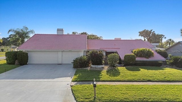 2886 Green Meadow Ct, Clearwater, FL 33761 - view of front of home with a tiled roof, a chimney, an attached garage, and driveway