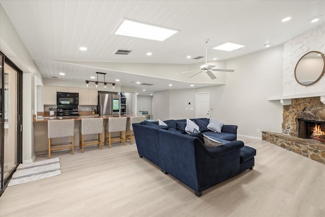 2886 Green Meadow Ct, Clearwater, FL 33761 - living room featuring light wood-style floors, a stone fireplace, lofted ceiling, recessed lighting, and a ceiling fan