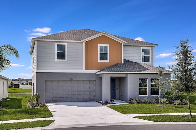 view of front of home featuring concrete driveway, a front lawn, roof with shingles, an attached garage, and stucco siding