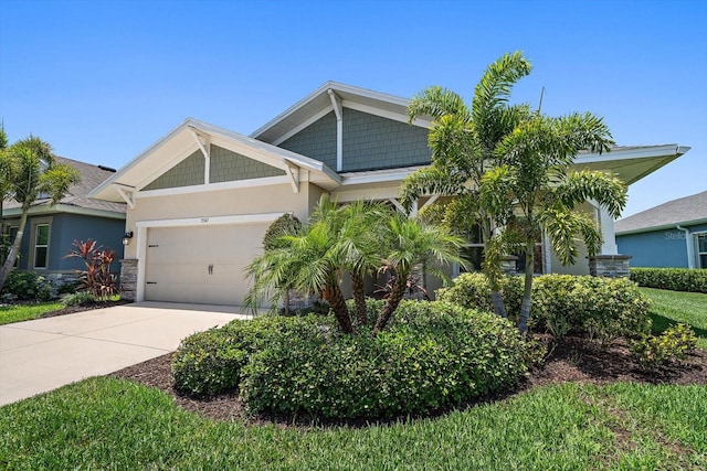 5547 Silver Sun Dr, Apollo Beach, FL 33572 - view of front facade with a garage, concrete driveway, stone siding, and stucco siding