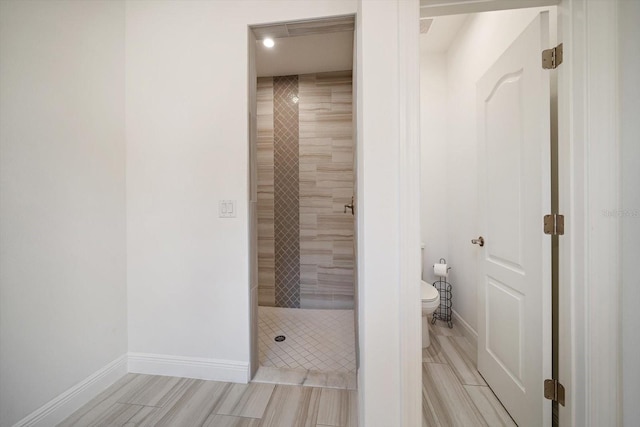 5547 Silver Sun Dr, Apollo Beach, FL 33572 - bathroom with baseboards, a tile shower, toilet, wood tiled floors, and recessed lighting