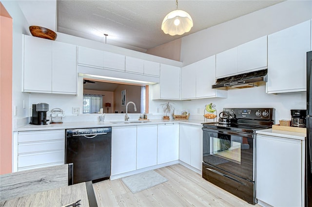 2139 Elm St Unit 308, Dunedin, FL 34698 - kitchen with black appliances, under cabinet range hood, a sink, light countertops, and a textured ceiling