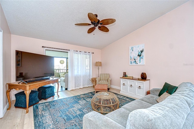 2139 Elm St Unit 308, Dunedin, FL 34698 - living room featuring vaulted ceiling, light wood-type flooring, a ceiling fan, a textured ceiling, and baseboards
