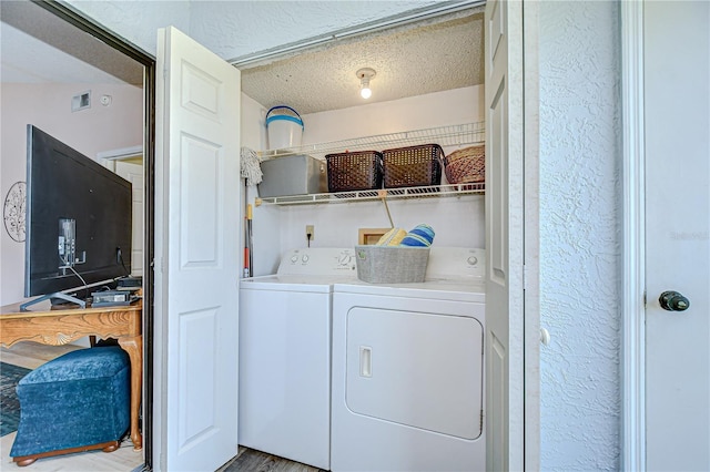 2139 Elm St Unit 308, Dunedin, FL 34698 - clothes washing area featuring washer and dryer, a textured ceiling, and a textured wall