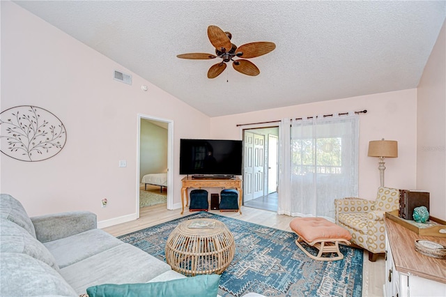 2139 Elm St Unit 308, Dunedin, FL 34698 - living area featuring a textured ceiling, light wood-type flooring, a ceiling fan, lofted ceiling, and baseboards