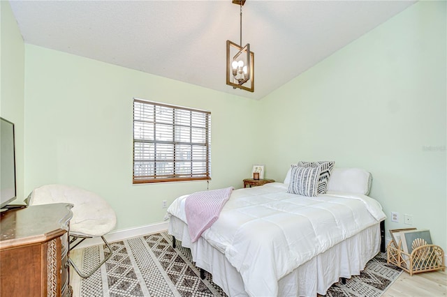 2139 Elm St Unit 308, Dunedin, FL 34698 - bedroom with lofted ceiling, baseboards, a chandelier, and wood finished floors