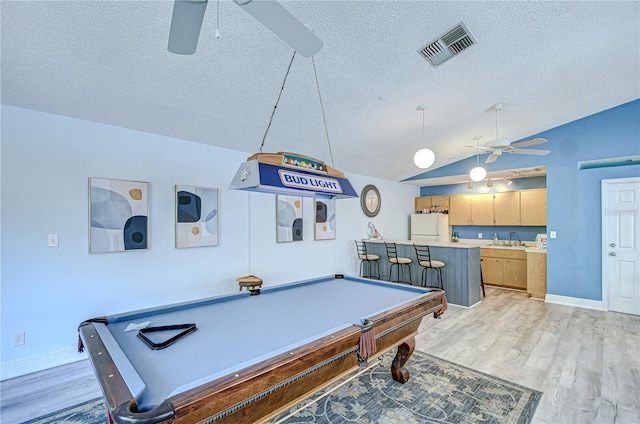 2139 Elm St Unit 308, Dunedin, FL 34698 - playroom featuring a ceiling fan, a sink, a textured ceiling, vaulted ceiling, and light wood finished floors