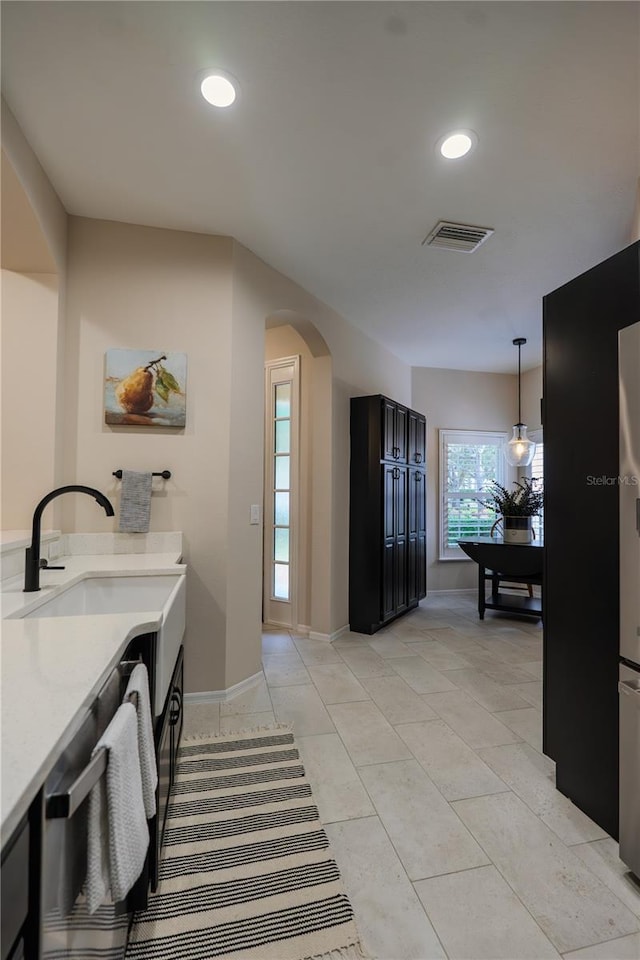 interior space featuring arched walkways, a sink, hanging light fixtures, recessed lighting, and baseboards