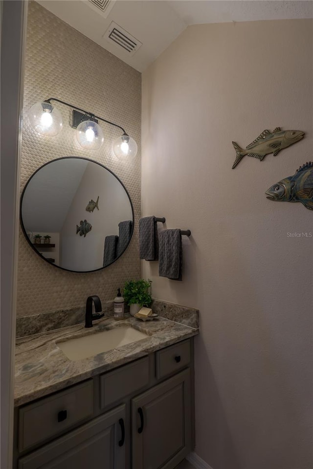 bathroom with vanity and vaulted ceiling