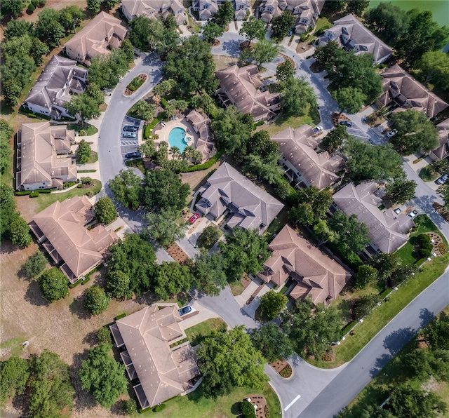 aerial view of property and surrounding area featuring nearby suburban area and a pool