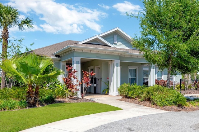 10142 Golden Wonder Ln, Riverview, FL 33578 - bungalow-style home featuring a porch, roof with shingles, a front yard, and stucco siding