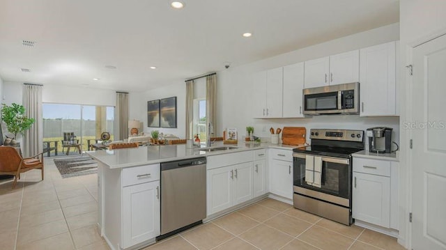 2415 Slippery Rock St, Auburndale, FL 33823 - kitchen with appliances with stainless steel finishes, a sink, a peninsula, light countertops, and white cabinets