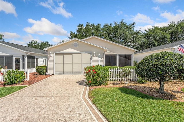 2121 Escobar Ave, Lady Lake, FL 32159 - ranch-style home featuring driveway, a sunroom, and a garage