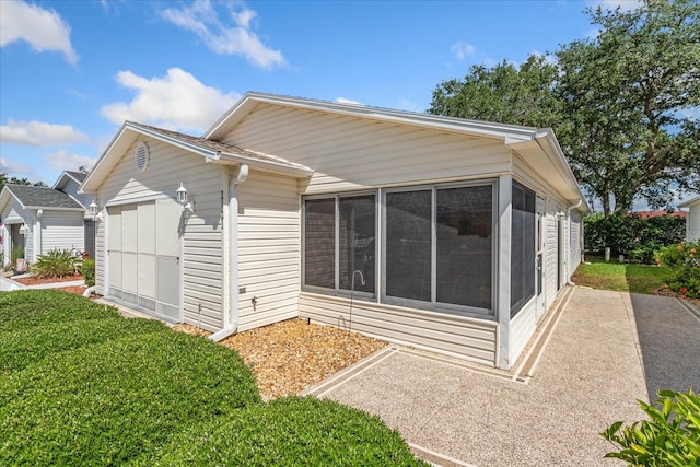 2121 Escobar Ave, Lady Lake, FL 32159 - back of property featuring a sunroom, an attached garage, and a yard