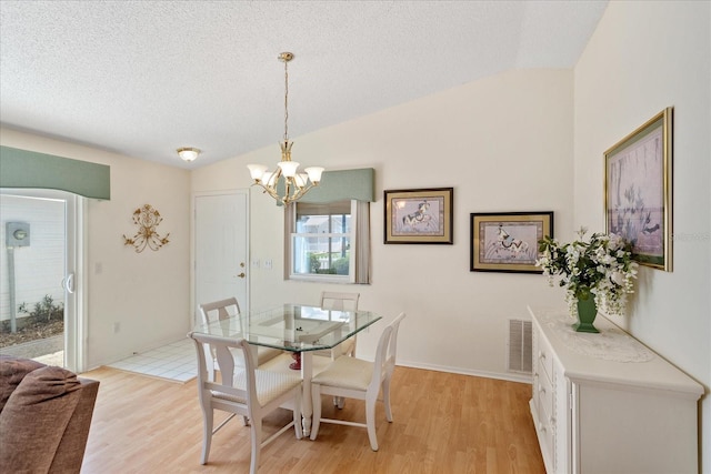2121 Escobar Ave, Lady Lake, FL 32159 - dining space featuring a chandelier, lofted ceiling, light wood-style floors, and a textured ceiling